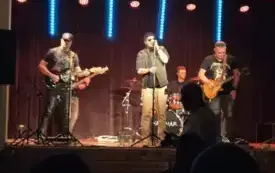 Kapela rockowa podczas koncertu na scenie z gitarami i perkusją