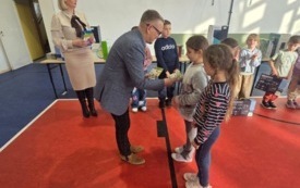 burmistrz wręcza nagrody dla ucznia na sali gimnastycznej