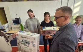 burmistrz wręcza nagrody dla ucznia na sali gimnastycznej