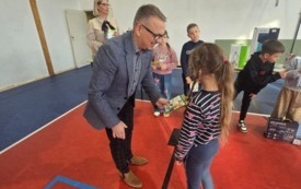 burmistrz wręcza nagrody dla ucznia na sali gimnastycznej