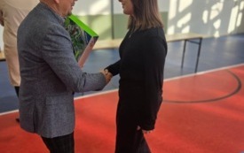 burmistrz wręcza nagrody dla ucznia na sali gimnastycznej