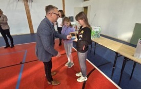 burmistrz wręcza nagrody dla ucznia na sali gimnastycznej