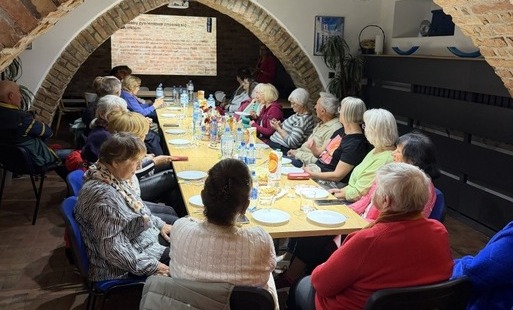 Seniorzy siedzący przy stołach